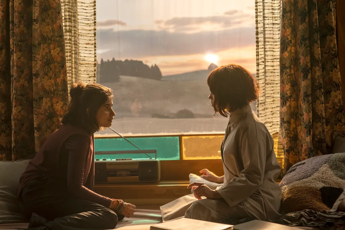 Jenna Ortega dans le rôle de Klara, assise près d'une fenêtre à la lumière du soleil dans Klara and the Sun