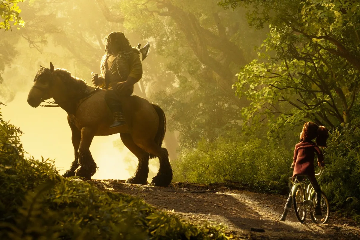 Une jeune fille à vélo rencontre un cavalier sur un chemin forestier dans Wildwood, film d'animation en stop-motion de LAIKA